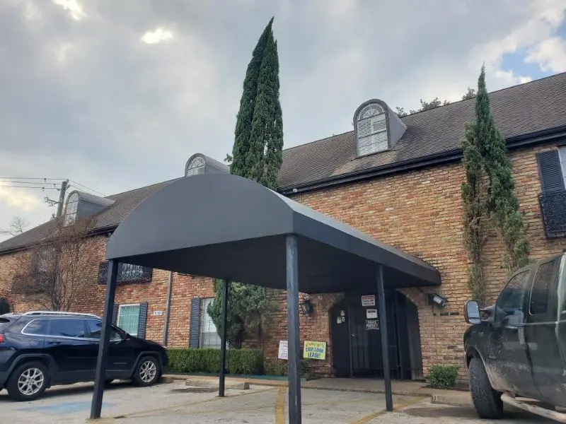 Brick building with parking lot and awning.