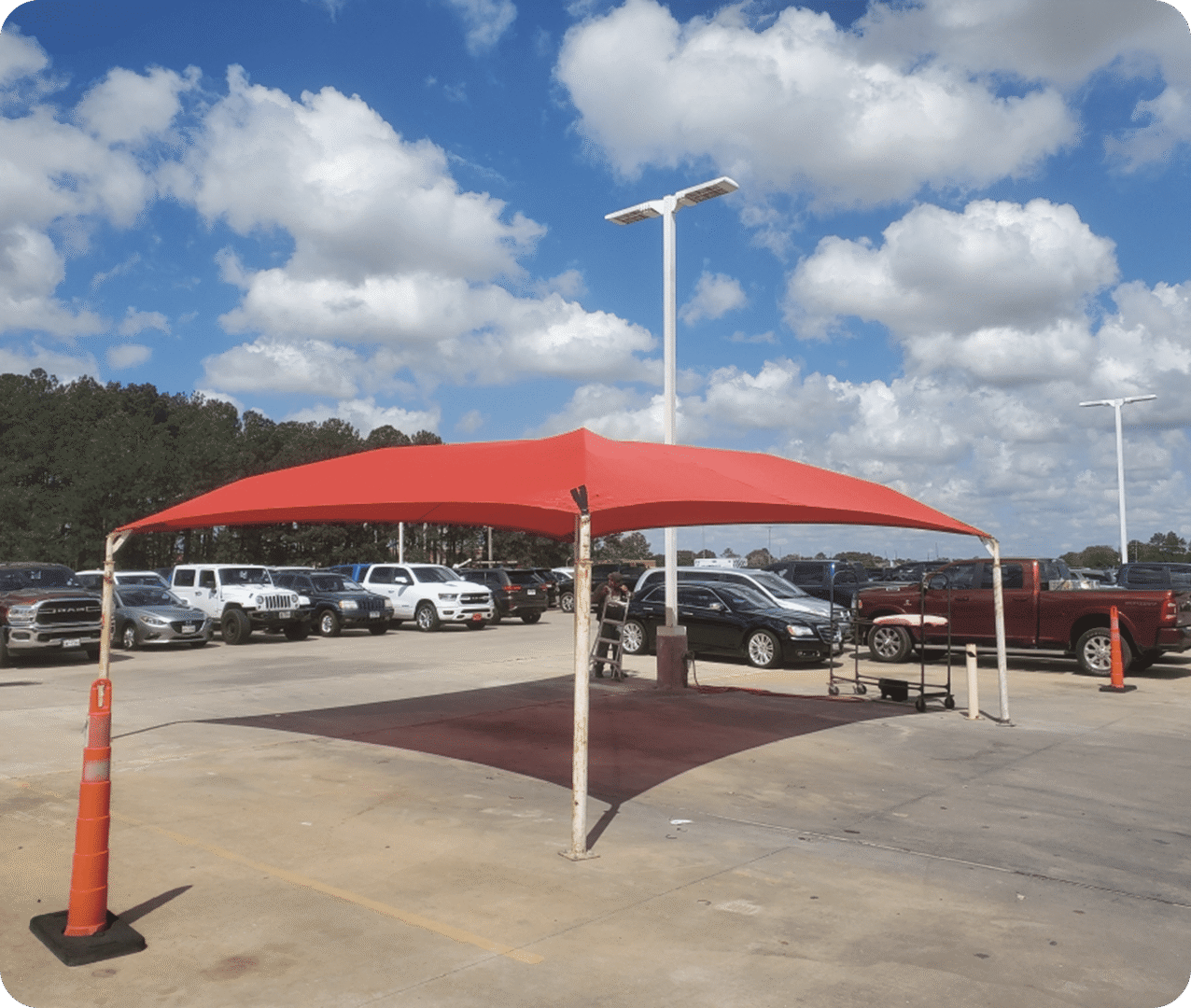 Red shade canopy over parked vehicles