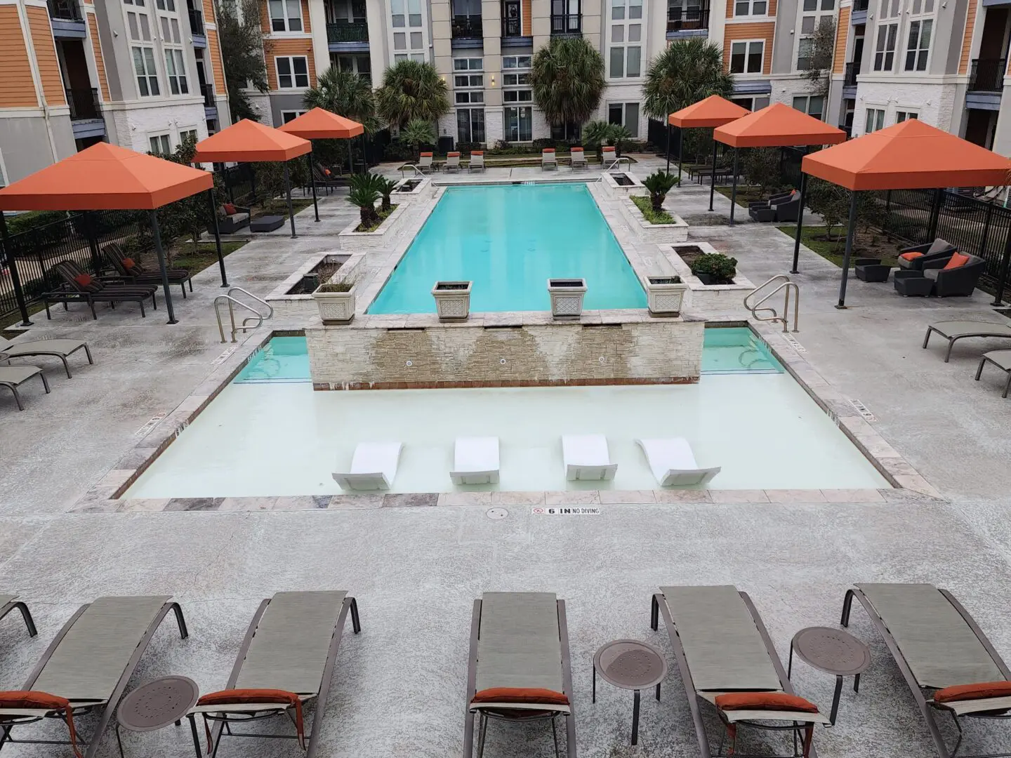 Luxurious outdoor pool area with lounge chairs and umbrellas.