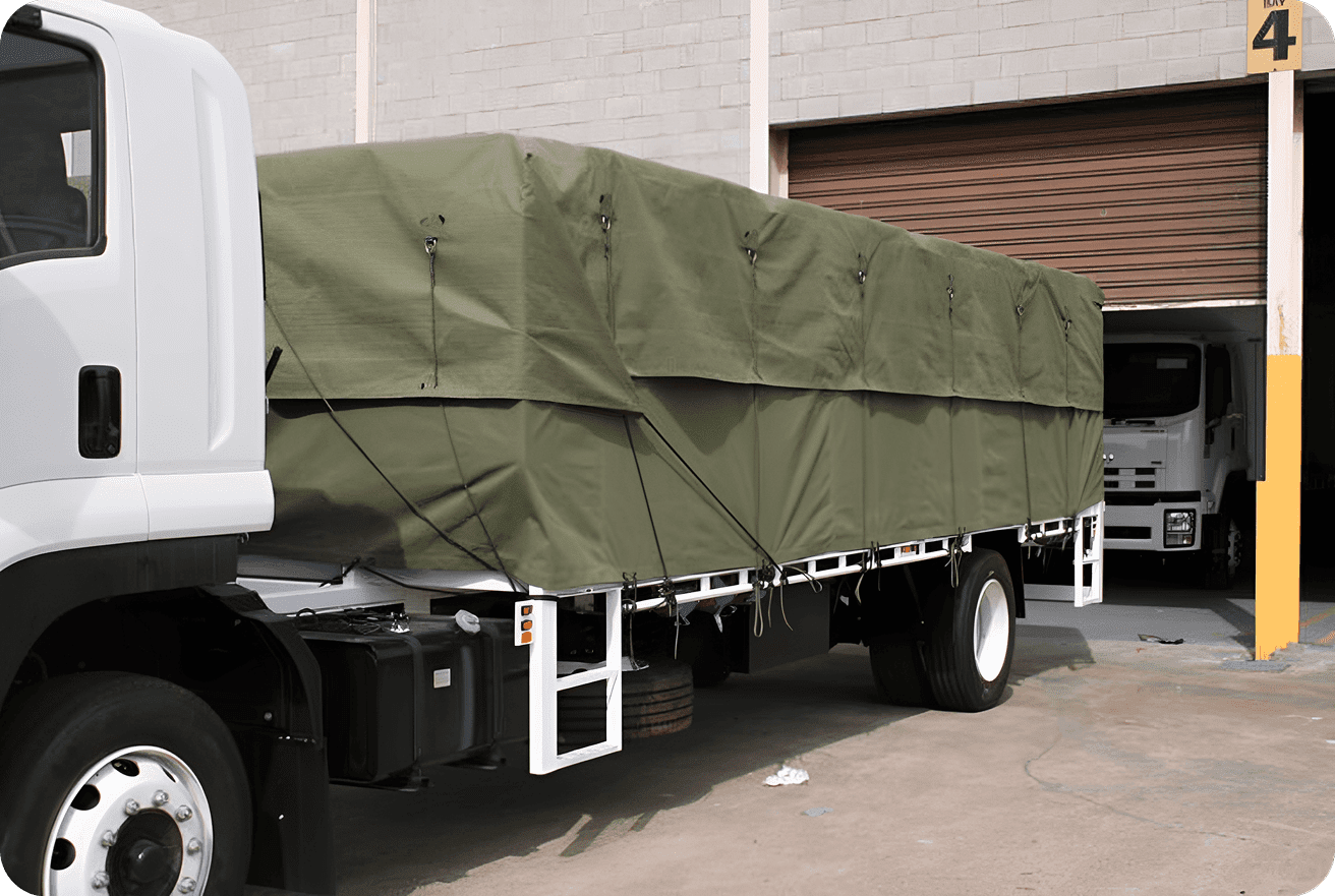 A truck with a green tarpaulin covering its cargo area.